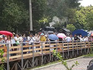 Yutengping railway station's wooden platform with steam locomotive number CK124 in the background.