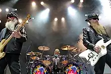 ZZ Top performing at St. Augustine Amphitheatre in Florida on May 22, 2008, from left to right: Dusty Hill, Frank Beard (drumming), and Billy Gibbons