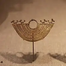 Zenú earring in the shape of a half moon, with elaborate filigree work