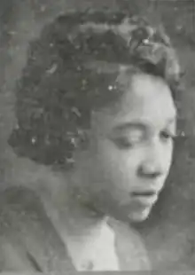 A young Black woman with her gaze cast downward, in 3/4 profile