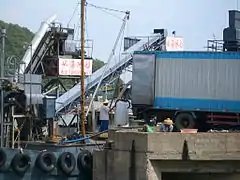 Loading blocks of factory-made ice from a truck to an ice depot boat