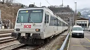 Boxy white train on track next to platform