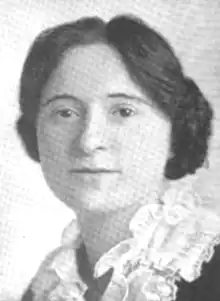 A young white woman with dark hair, wearing a white lace collar