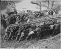 US troops launching a Bailey bridge across a gap by hand