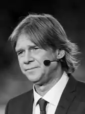 A man in a suit speaking in a wireless headset
