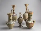 Whitewashed amphorae with colorful floral designs on the shoulders