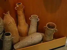 Aparecen varias vasijas y ánforas de la Edad Antigua en San Fernando, Cádiz. Estas aparecen inclinadas sobre una pared de fondo rojo.