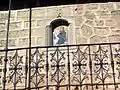 Vista del plafón de san Antonio de Padua en la fachada de una casa de Ademuz (Valencia), con detalle de balcón de forja, s/f.