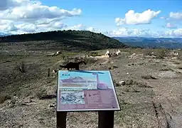 Vista de la plaza Mayor del barrio minero de La Azufrera de Libros (Teruel), con detalle del panel informativo existente en la placeta del oratorio, año 2016.