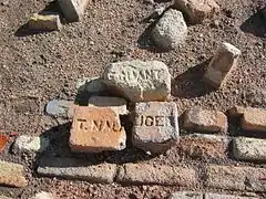 Vista de las ruinas del barrio minero de «La Azufrera» de Libros (Teruel), con detalle de ladrillos con marcas de fábrica junto al antiguo gran almacén, año 2016.