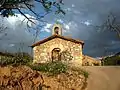 Vista frontal de la ermita de San Miguel Arcángel en Val de la Sabina, Ademuz (Valencia), con detalle del camino de acceso.