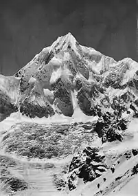 Vista del Siniolchu (6.888 m), desde el glaciar de Zemu (29 km hacia 1900); nótese a los alpinistas avanzando en la parte inferior derecha.