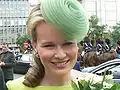 La reina Matilde de Bélgica llevando un ligero fascinador verde.