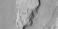 Vista ampliada de una parte de imagen anterior, ambas imágenes tomadas por la cámara HiRISE y su programa HiWish.  El rectángulo representa la medida de un campo de fútbol