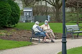 Pareja de ancianas, la principal población vulnerable en la pandemia, respetando el distanciamiento social en un parque de Geneva.