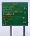 Una señal escocesa en la isla de Skye, con nombres escritos en Gaelico Escocés e inglés, y mostrando las distancias en millas.