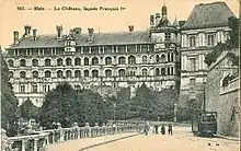 Un coche del tranvía de Blois pasando abajo del castillo, a principios del siglo xx.