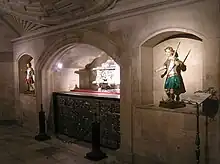 Cripta de la catedral de Alcalá de Henares, con la urna de las reliquias de los santos, de 1702, y la piedra donde fueron degollados.