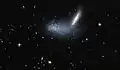La galaxia enana irregular PGC 16389 cubre a la galaxia vecina APMBGC 252+125-117.