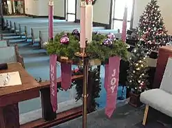 Corona de Adviento con una vela rosa para encender durante el Gaudete, en una iglesia metodista