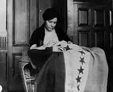 Alice Paul cosiendo una bandera con los colores del NWP