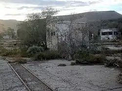 Restos supervivientes de una terminal en el interior del predio con una vía al costado y con su andén aun intacto.