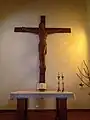 Altar de la iglesia con un Cristo crucificado tallado en madera. Obra de Peter Horn Werner