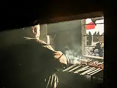 Un hombre cocinando una barbacoa para los peregrinos.