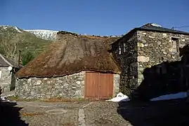 Palloza y su evolución hacia casa de piedra con tejado de pizarra.