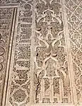 Motivos arabescos y piñas junto con inscripciones caligráficas alrededor del mihrab de la Madrasa de Ben Youssef, en Marrakech (siglo XVI)