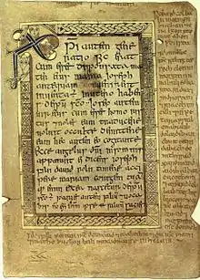 Texto de Mateo 1:18 al 21 en el folio 5r del Libro de Deer, ca. 1100. Arriba, a la izquierda, el monograma Chi Rho (Crismón). En el margen, glosas gaélicas.