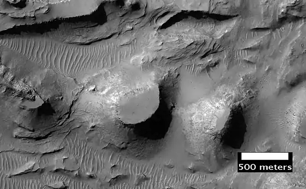 Erosión de los estratos bajos en el Cráter Bouguer (imagen del HiRISE). Esta imagen es de una parte diferente del cráter que muestra la imagen de la derecha.