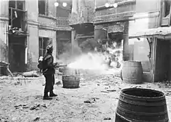 Un soldado alemán prende fuego a un edificio