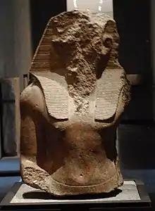 Upper part of the statue of an Egyptian pharaohs, its face acked off.