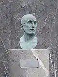 Busto de José María Arizmendiarrieta en bronce y piedra, estructura de acero y madera.