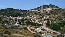 Pueblo con muchas casas de diversas formas. Se ven montañas al fondo en lo alto y las casas en un valle.