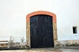 Vista parcial de la fachada de la Ermita de la Virgen de Gracia (Castielfabib, Valencia), con detalle del arco rebajado de la entrada (2018).