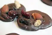 Dos mendiant, hechos con chocolate negro y frutos secos.