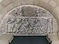 Tímpano de la puerta del claustro. Arriba, crismón, abajo la Epifanía