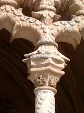 Capitel, en el claustro de Juan I, en el Monasterio de Batalha, donde es visible uno de los dos motivos emblemáticos del estilo manuelino, la Cruz de la Orden de Cristo.