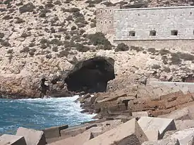 Cueva de los Aviones, bajo el Fuerte de Navidad, donde se han encontrado cuentas de un collar neandertal de hace 50 000 años, antes de la convivencia con H. sapiens.