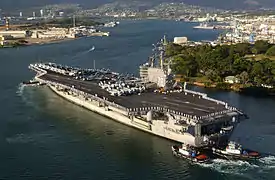 El USS Ronald Reagan (CVN 76) es ayudado a ingresar a Pearl Harbor, Hawái por los remolcadores del puerto, durante una visita realizada el 28 de junio de 2006.