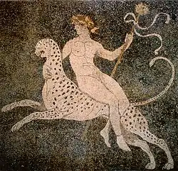 Dionisos, con su tirso, monta un leopardo en un mosaico de Pella.