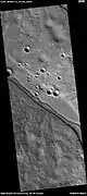 Canal angosto dentro de un canal más ámplio, observado por HiRISE en el programa HiWish. La existencia del canal más pequeño sugiere que agua atravesó la región al menos dos veces en el pasado.