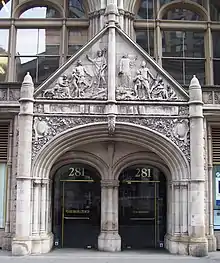 Detail of the entrance to the building, with a carved triangular pediment above the doorways