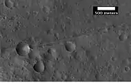 Primer plano de una posible falla en Mare Acidalium, vista por HiRISE bajo el programa HiWish. Se dibuja un círculo alrededor del cráter para mostrar que puede estar desviado debido al movimiento de la falla. Hay muchas otras fallas en la región