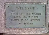 A metallic plaque with the words "Fort Orange: Site of West India Company Colony 1624, was located to the southeast by the river."