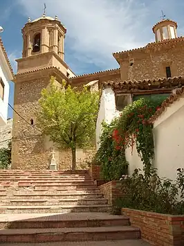 Vista de una calle de Foz-Calanda, con la Iglesia de San Juan Bautista al fondo.