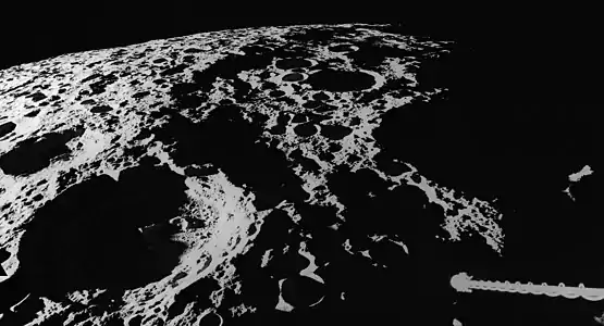 Vista del brocal del oeste de la cuenca en el ocaso lunar (Apolo 16). Spencer Jones aparece abajo a la izquierda, con el espectrómetro de rayos gamma de la aeronave abajo a la derecha.