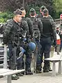 Miembros de la Gendarmería Nacional francesa con su armadura corporal, cascos, escudos, lanzagranadas (para gas lacrimógeno) y máscaras antigás.